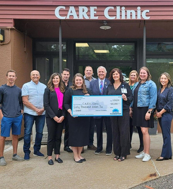 Patterson and CARE Clinic employees posing for a check presentation